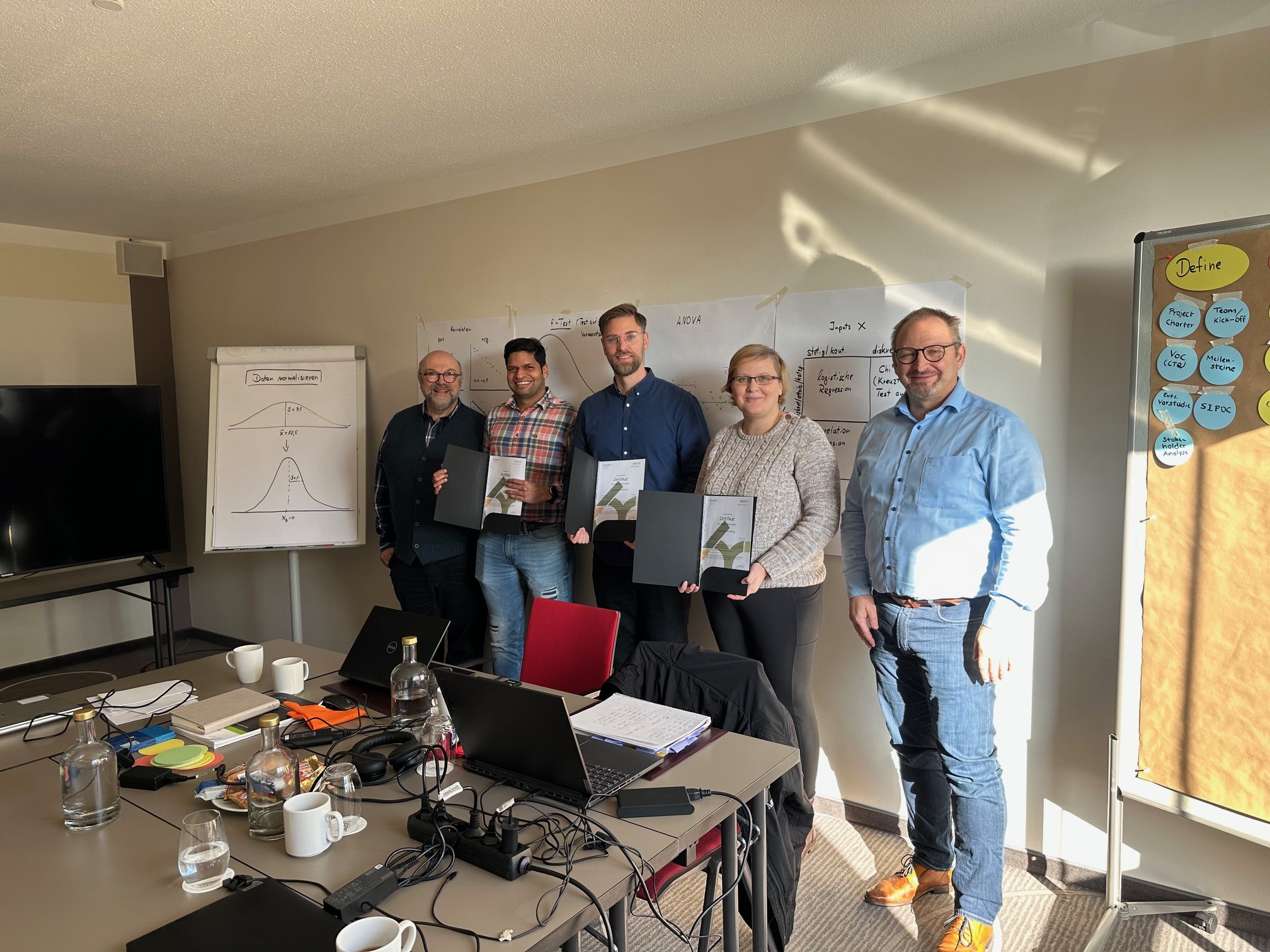 Teilnehmende der Lean Six Sigma Black Belt Ausbildung in Frankfurt-Oberursel mit Trainer Michael Kierdorf und Akademieleitung Markus Maier bei der Zertifikatsübergabe im Raum Bergkristall.